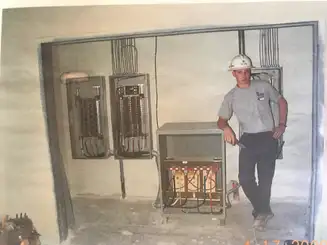 Jesse Dunlap standing next to commercial electrical switchgear and transformers