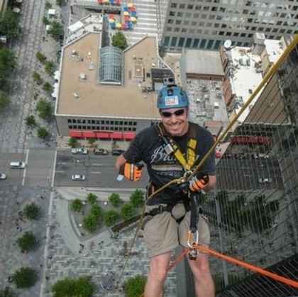 Jesse Dunlap rappelling down a building for the Over the Edge fundraiser for Cancer League of Colorado