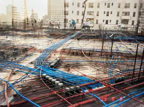 Commercial building deck before concrete pour with conduit runs, rebar, and electrical rough-in