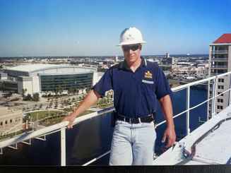 Jesse Dunlap on top of a 200-foot tower crane in Tampa, Florida during the Harbour Island project, wearing a Tri-City Electrical Contractors hardhat
