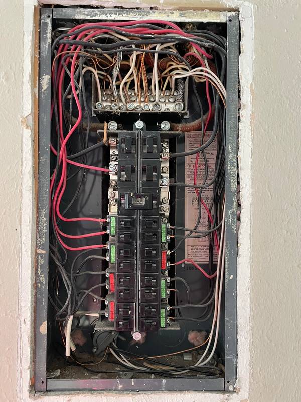 Inside of a Pushmatic Bulldog panel showing push-button breakers, MAIN LIGHTING label, and aging wiring in a Denver-area home