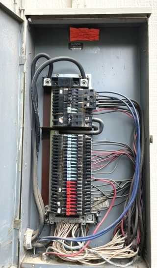 Zinsco electrical panel with colored breaker handles showing blue, red, and green on the bus bar