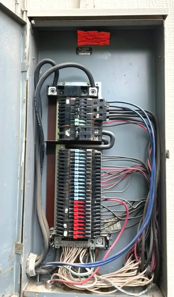 Zinsco electrical panel with colored breaker handles — blue, red, and green visible on the bus bar
